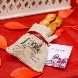 Sachet en jute écriture "Love" sur nappe rouge avec des pétale rouge (x12)