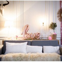 Ballon "love" géant rose gold sur une table