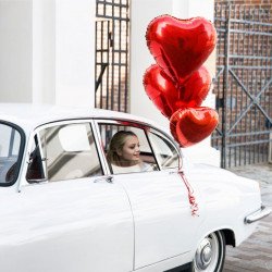 Grand ballon mylar coeur rouge accroché sur une voiture de mariage