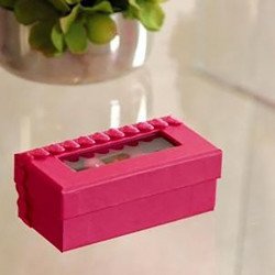 Boîte rectangulaire fuchsia sur une table avec une plante en arrière plan(x6)