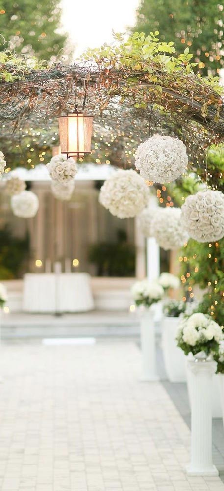 décoration fête chic theme princesse, boules de fleurs blanches a suspendre aux branches avec guirlandes de perles