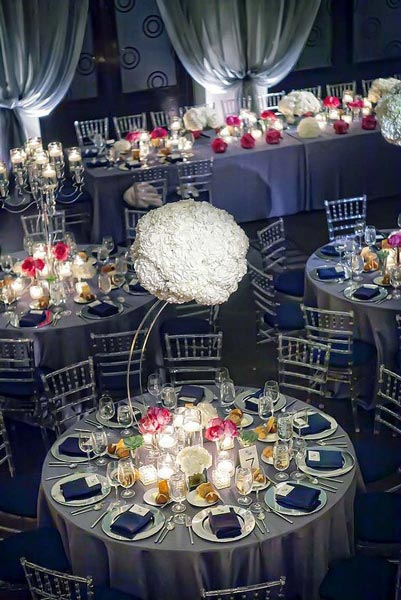 Grosse boule de fleurs blanche au dessus des tables des invités